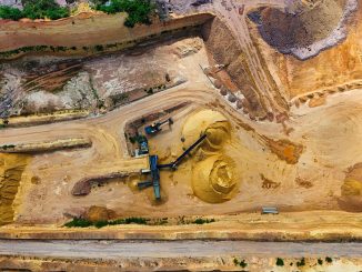 Minh họa mỏ đá vôi lộ thiên nhìn từ trên cao với máy xúc và bãi vật liệu