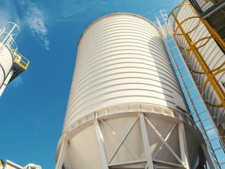 Các silo chứa màu trắng với cầu thang thép nhìn từ dưới lên