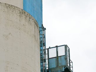 Minh họa silo bê tông và thang bảo trì xanh tại nhà máy công nghiệp